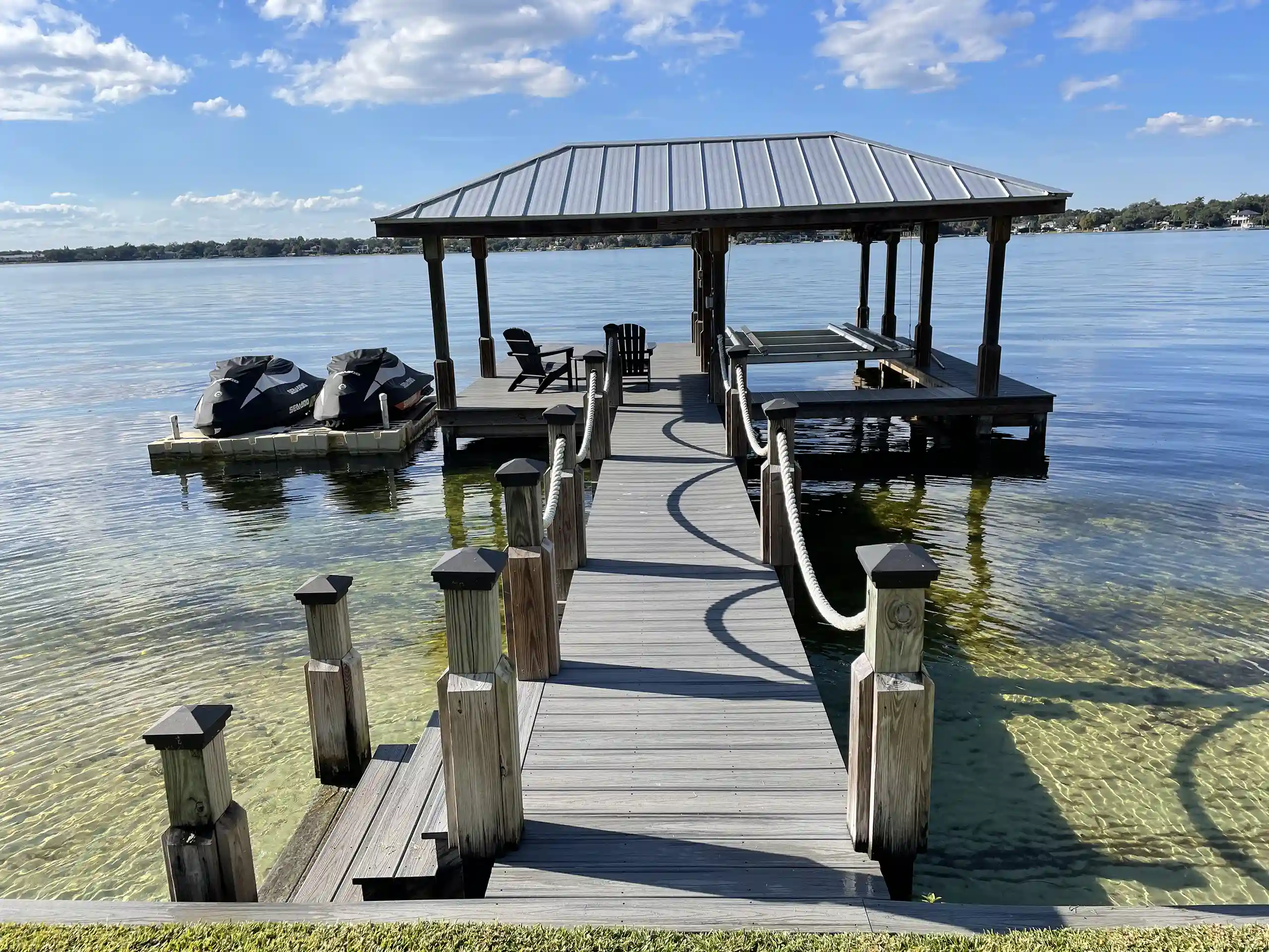 photo of a boat house with boat lift and floating personal watercraft dock