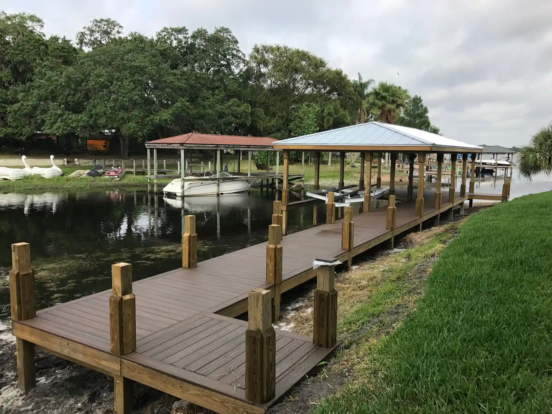 photo of a canal front covered boat dock, boat lift, with walkway
