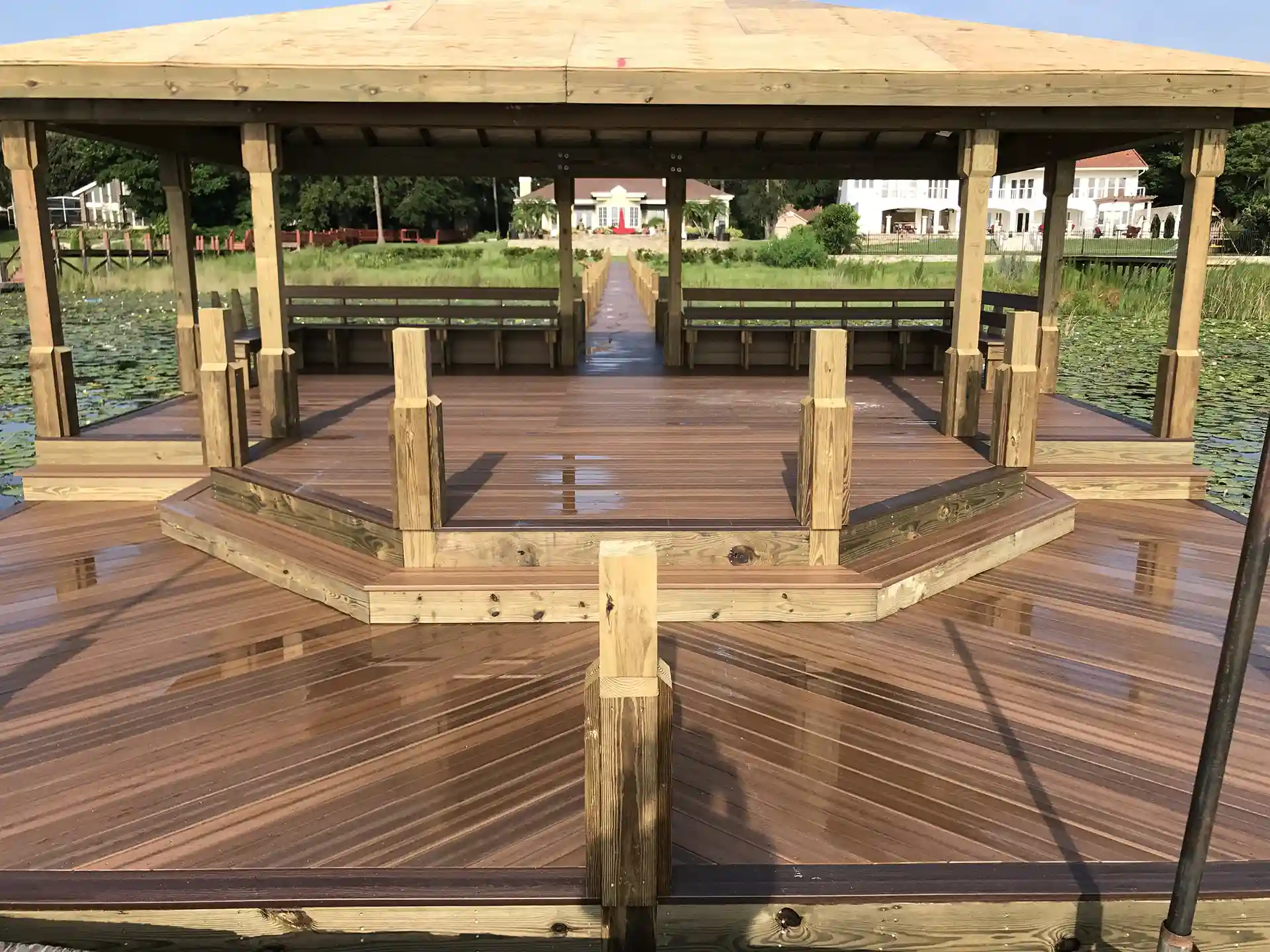 covered dock with composite decking, built-in benches, and a scenic waterfront view.